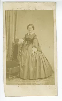 portrait photographique en pied de Juliette Gide, de face, près d’une chaise