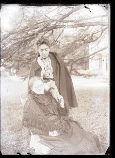 photographie de Madeleine Gide, debout, tenant la main d'Emma Siller, sa gouvernante allemande, dans le jardin du château de Cuverville