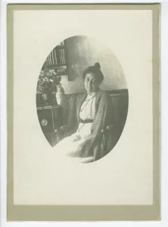 portrait photographique de Madeleine Gide, assise près d’un bouquet de fleurs