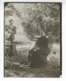 photographie de Lucile Rondeaux, tante maternelle par alliance d'André Gide, assise, et Emma Siller, la gouvernante allemande de Madeleine Rondeaux, dans le jardin du château de Cuverville