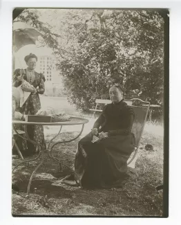 photographie de Lucile Rondeaux, tante maternelle par alliance d'André Gide, assise, et Emma Siller, la gouvernante allemande de Madeleine Rondeaux, dans le jardin du château de Cuverville