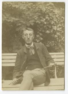 photographie de Théo Van Rysselberghe, assis sur un banc, avec une cravache