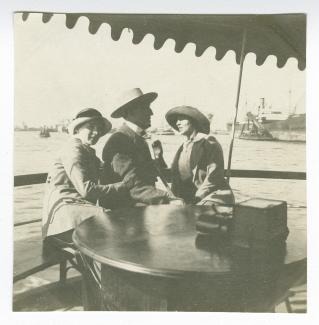photographie montrant, de gauche à droite, Daisy Weber, Théo Van Rysselberghe et Élisabeth Van Rysselberghe, assis sur le pont d'un bateau