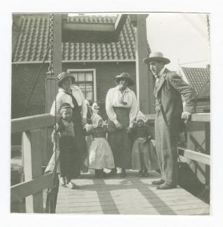 photographie montrant Théo Van Rysselberghe, Marie-Thérèse Muller et Élisabeth Van Rysselberghe tenant la main à deux fillettes en habit traditionnel, sur un petit pont