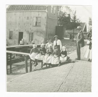 photographie montrant Théo Van Rysselberghe, Marie-Thérèse Muller et Daisy Weber (à gauche) devant des femmes et des enfants en habit traditionnel