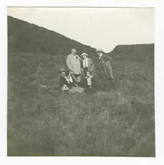 photographie montrant, de gauche à droite, debout, Octave Maus, Madeleine Maus et Théo Van Rysselberghe, et assises, Daisy Weber, Élisabeth Van Rysselberghe, et Marie-Thérèse Muller, dans la campagne, août 1914