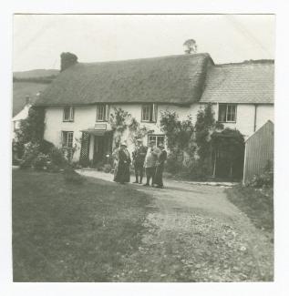 photographie montrant Madeleine Maus (tenant une canne), Théo Van Rysselberghe, au centre, Octave Maus et Daisy Weber, devant une maison, août 1914