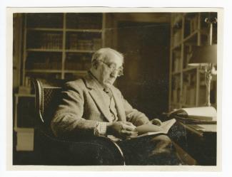portrait photographique de Théo Van Rysselberghe, lisant, devant un bureau, au château du Tertre chez Roger Martin du Gard, octobre 1926