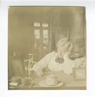 portrait photographique de Maria Van Rysselberghe, assise à un bureau, chez les Mayrisch