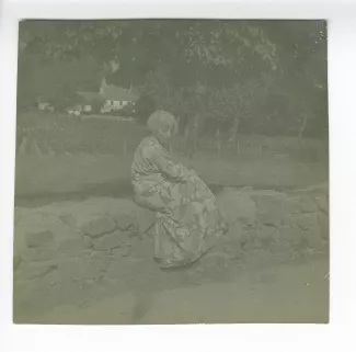 photographie de Maria Van Rysselberghe, assise sur un muret, juillet-août 1907