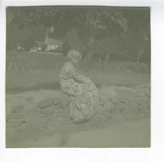 photographie de Maria Van Rysselberghe, assise sur un muret, juillet-août 1907