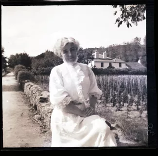 portrait photographique de Maria Van Rysselberghe, assise sur un muret, août 1908