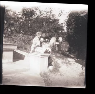 photographie de Maria Van Rysselberghe, assise devant des jarres, à la villa d'Octave Van Rysselberghe, à Saint-Clair, novembre 1908