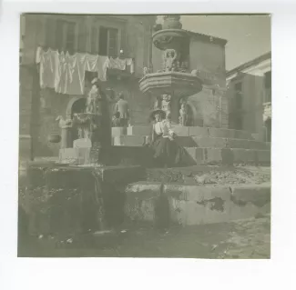 photographie de Maria Van Rysselberghe, assise sur les marches devant la fontaine de la Piazza del Duomo, décembre 1908