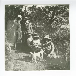 photographie où l'on reconnaît Maria Van Rysselberghe, deuxième à gauche, Marie Closset [?] assise à ses pieds, Marie-Thérèse Muller, première assise à droite, avec le chien Nick, en promenade, à Saint-Clair