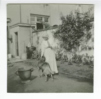 photographie de Maria Van Rysselberghe, dans un jardin avec un chien