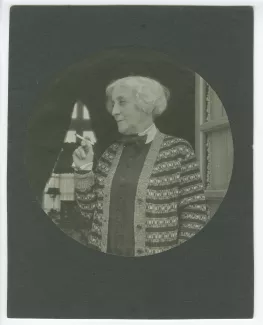 portrait photographique en buste de Maria Van Rysselberghe, fumant devant une porte-fenêtre, au château du Tertre, chez Roger Martin du Gard, mai 1927