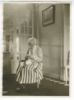 photographie de Maria Van Rysselberghe, tricotant, au château du Tertre, chez Roger Martin du Gard, mai 1927