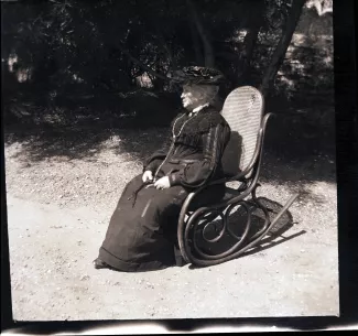 photographie de Sylvie Monnom, mère de Maria Van Rysselberghe, assise dans un rocking-chair, en extérieur, avril 1905