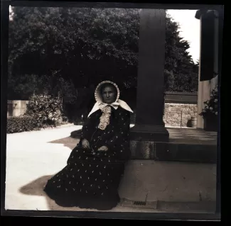 photographie de Sylvie Monnom, mère de Maria Van Rysselberghe, portant une coiffe, assise sur les marches du perron de la maison louée par les Van Rysselberghe à St. Brelade, été 1907