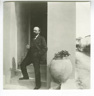 photographie d'Henri Ghéon, fumant sur l'escalier d'entrée de la villa de Saint-Clair