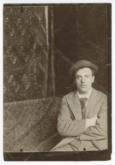 portrait photographique de (Jean-)Pierre Laurens, frère de Paul-Albert Laurens, assis devant un tapis suspendu au mur