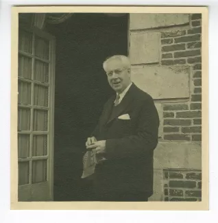 photographie de Roger Martin du Gard, devant une entrée, dans sa propriété du Tertre