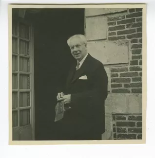 photographie de Roger Martin du Gard, devant une entrée, dans sa propriété du Tertre