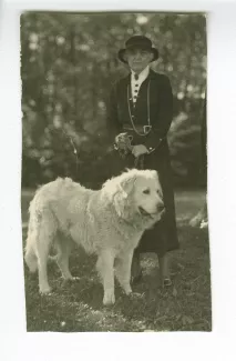 portrait photographique en pied d'Aline Mayrisch, tenant en laisse le chien Hund, en extérieur