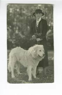 portrait photographique en pied d'Aline Mayrisch, tenant en laisse le chien Hund, en extérieur