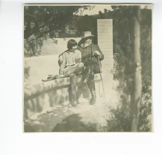 photographie d'Andrée Mayrisch et son père Émile Mayrisch, assis sur un banc de pierre, dans le jardin de leur propriété de la Malbuisson