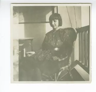 photographie d'Andrée Mayrisch enfant, aux cheveux longs, assise, sur un balcon de la villa de Saint-Clair