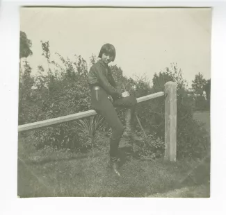 photographie d'Andrée Mayrisch, assise sur une haie, été 1913