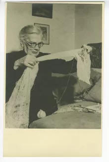 portrait photographique de la comtesse Tatiana Soukhotine-Tolstoï, fille de l'écrivain, assise sur un lit, une étoffe en crochet entre les mains