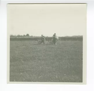 photographie de deux élèves de l'école d'horticulture, dans un champ avec des vélos