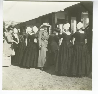 photographie de Marie-Thérèse Muller au milieu d’un groupe de femmes, devant un train, à la gare ferroviaire